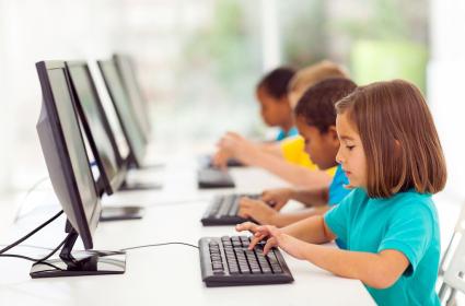 elementary aged students typing at computers 